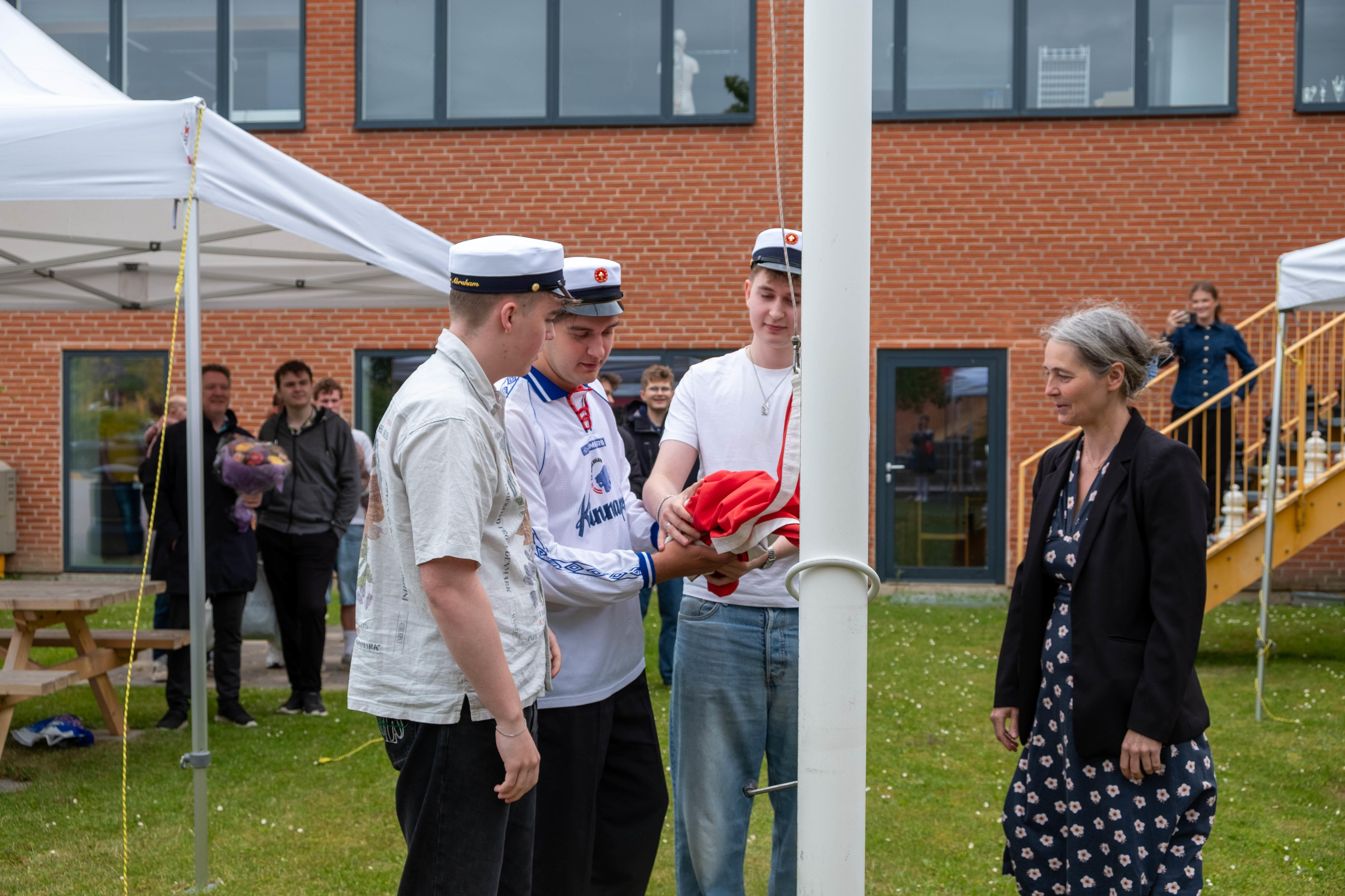 Traditionen skal årets første studenter hejse flaget på HTX Køge. Her ses sidste års studenter med rektor Nynne Afzelius.